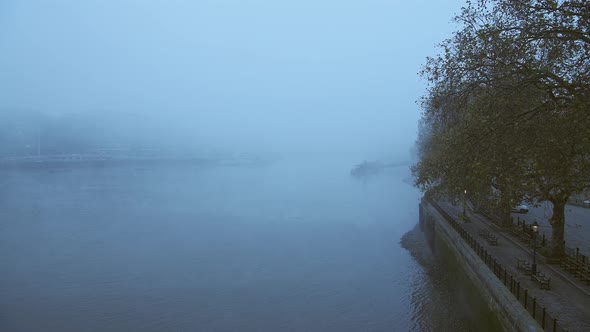 Foggy and misty atmospheric River Thames in London on Coronavirus Covid-19 lockdown day one, showing