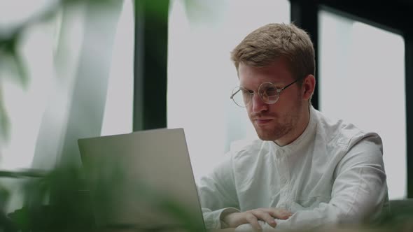 Adult Man is Watching Video on Display of Laptop Reading News in Internet Portrait of Person with