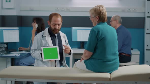 Doctor and Senior Woman Looing at Horizontal Green Screen