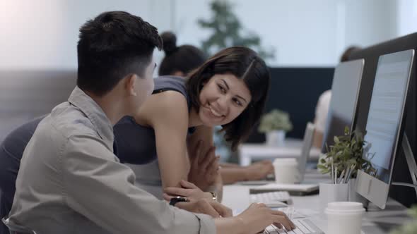 Female Office Worker Helping Male Colleague