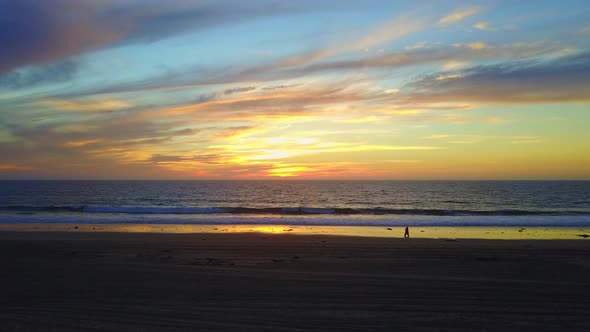 Aerial drone view of a sunset at the beach over the ocean.