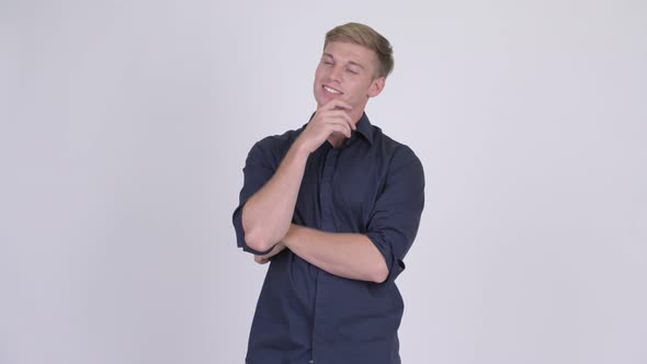 Young Happy Blonde Businessman Smiling and Thinking