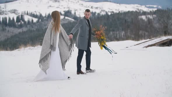 Couple Walking on a Snowy Lawn