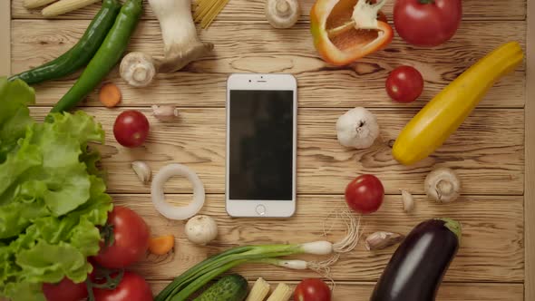 Faceless Cook Taking Phone From Kitchen Counter with Ingredients