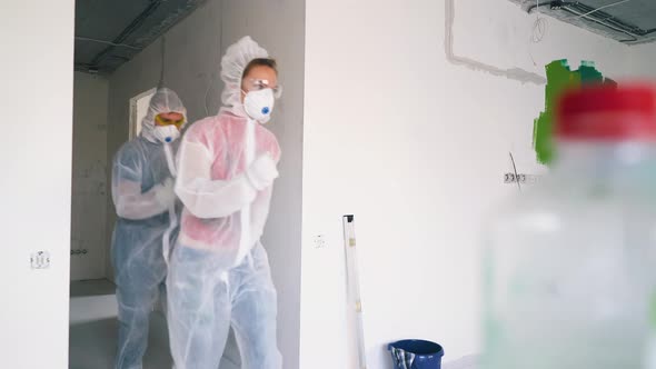 Funny Couple in Protective Suits Comes Dancing Into Room