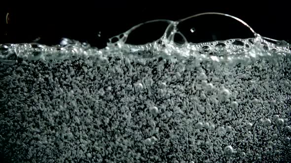 Pouring fizzy water in the glass.