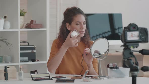 Beauty Vlogger Applying Highlighter on Face