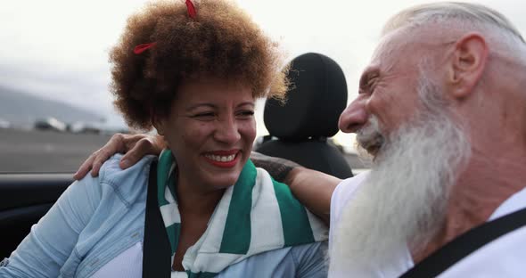 Trendy elderly couple having fun doing a road trip during vacation