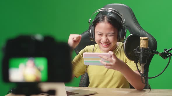 Camera And Kid Girl Playing Video Game On Phone And Celebrating While Live Stream On Green Screen