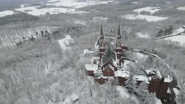 Panoramic view high on mountain of religious complex. Multiple buildings with snow.