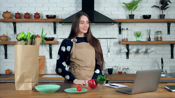 Woman greets listen tells teacher online laptop, culinary school in kitchen