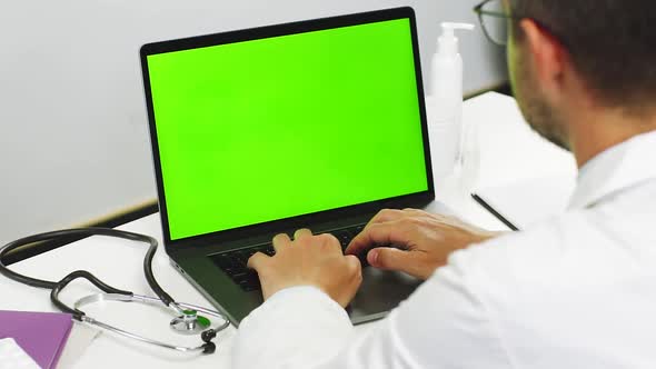 Doctor Working Online Through Green Screen Laptop