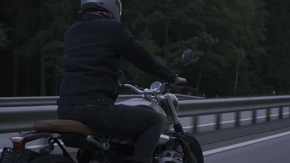 Man Riding Scrambler Motorbike on the Highway Through the Dark Forrest