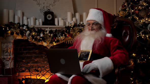 Modern Santa Claus Uses Laptop Fills in Holiday Cards Children Happy New Year