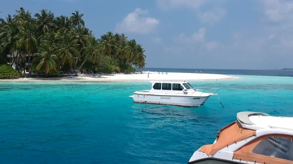 Boats near beautiful island beach in Maldives - Drone