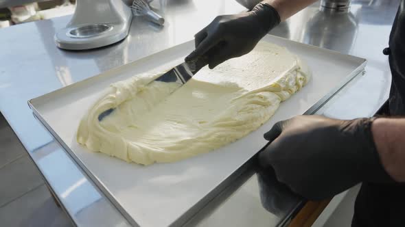 Male Hands Spreading Raw Dough on Metal Baking Tray