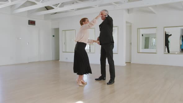 Caucasian senior couple spending time together dancing in a ballroom