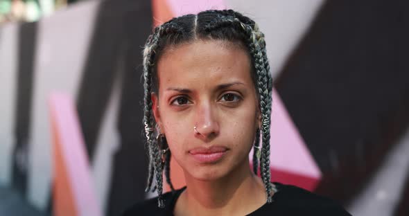 Trendy young woman with braided hair looking on camera