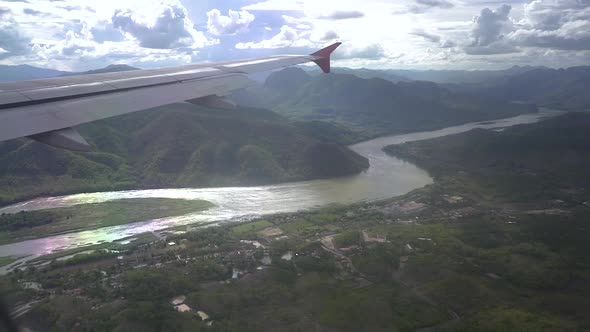 looking outside the airplane window when the plane is passing the mekong river in Laos