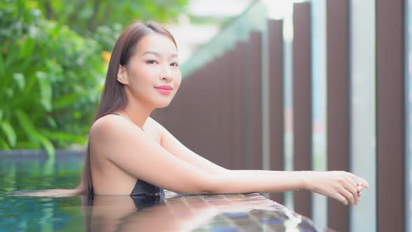 Young asian woman enjoy around outdoor swimming pool for leisure