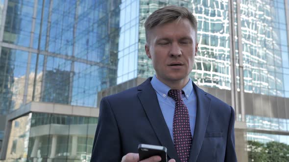 Businessman Attending Phone Call While Walking to Office Phone Talk