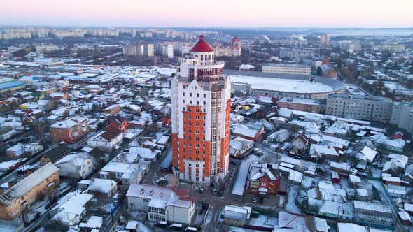 Aerial View of Drone Flying Over Tall Building in Small European City in Winter Sunset