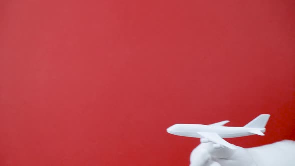Santa Holding a Toy Airplane on Red Background