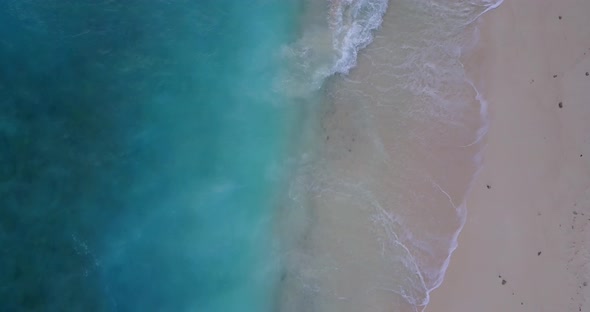 Wide drone tourism shot of a paradise sunny white sand beach and blue sea background in colourful 4K