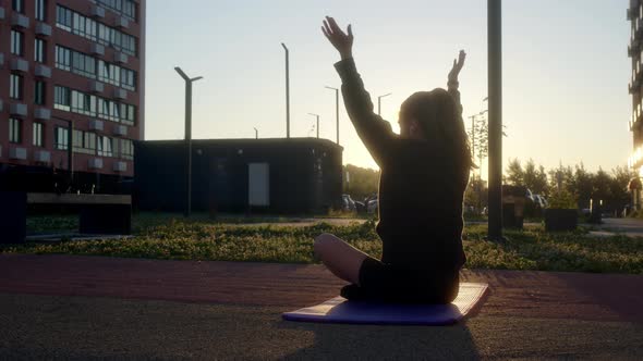 Young Woman is Warming Up on Sports Ground in Residential Complex