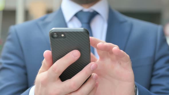 Hands Close up of Businessman using Smartphone while Standing in Street