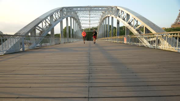 A couple running across a bridge