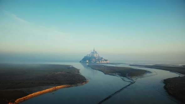 Drone Flying Towards Foggy Mont Saint Michel on Epic Sunrise High Tide, Iconic Island Fortress
