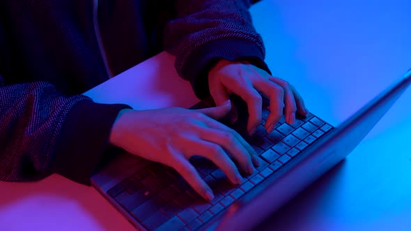 A Young Woman Is Typing on a Laptop Keyboard. Hands Close Up. Hacker Makes a Hack Through a Laptop