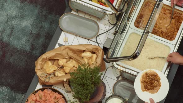 The view from above of the buffet, and the people picking up their food. Space for title.