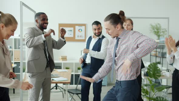 Slow Motion of Creative Guy Dancing in Office in Circle of Applauding Coworkers