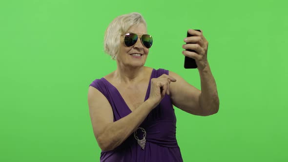 An Elderly Woman Make a Photo on a Smartphone. Selfie. Chroma Key