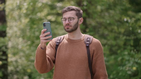 Man Hiker Using Smartphone While Enjoying Weekend in Forest