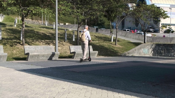 Unrecognizable senior man riding on electric scooter in a park