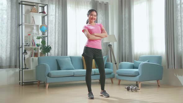 Asian Girl In Sportswear Is Posing With A Soft Smile In Her Living Room