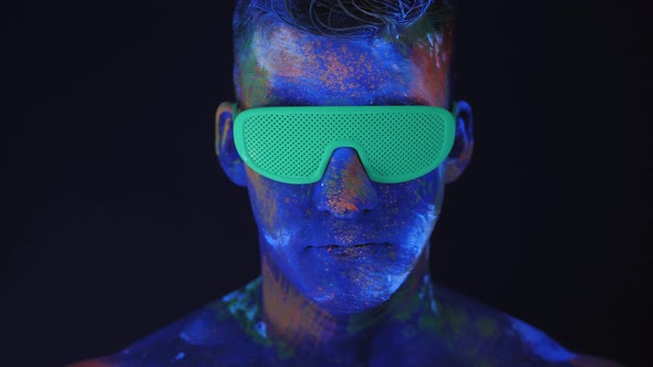 Closeup of a Man with Drawings on His Body Take Off Green Glowing Disco Glasses