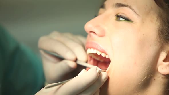 Dental assistant and little girl doing high-five after teeth checkup