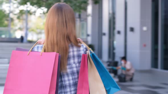 Smiling young Asian woman with shopping colour bags