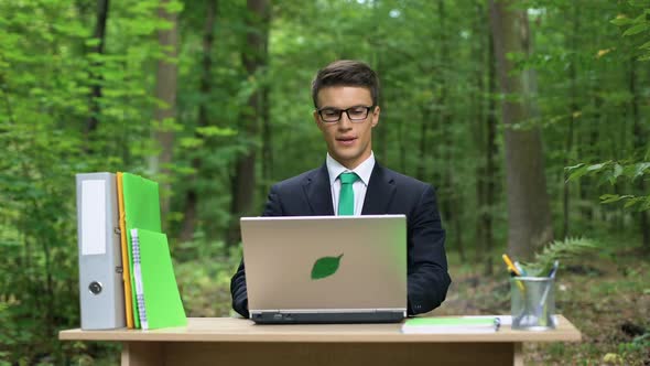 Businessman Deeply Breathing Fresh Air in Eco-Friendly Office, Working on Laptop