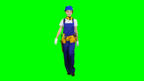 Girl Builder Is Walking Along the Street and Waving Her Hand To Others. Green Screen