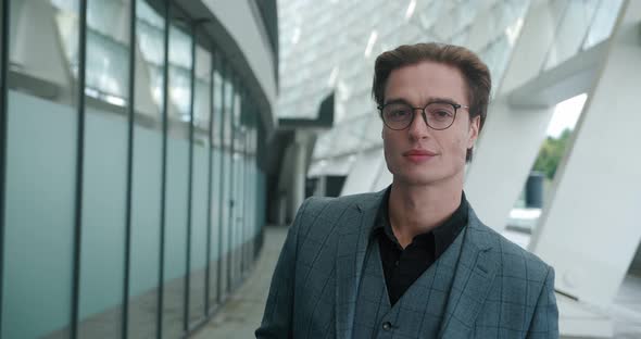 Closeup Portrait of Smiling Ceo Executive Putting on Glasses and Looking to Camera