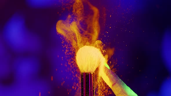 Glowing Neon UV Powder on a Makeup Brush Flying Away with Woman Finger Flicking on Neon Background