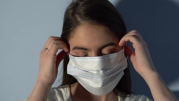 Woman Putting On Medical Face Mask For Virus Infection Prevention And Protection