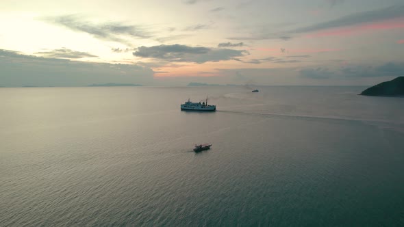 Ferry and small fishing boat cruising in sea, coast of Koh Samui, Thailand with a beautiful sunset