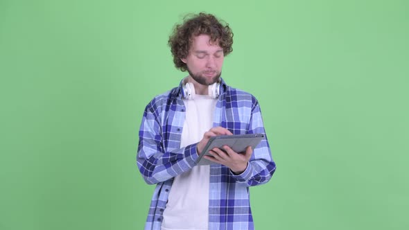Happy Young Bearded Hipster Man Using Digital Tablet