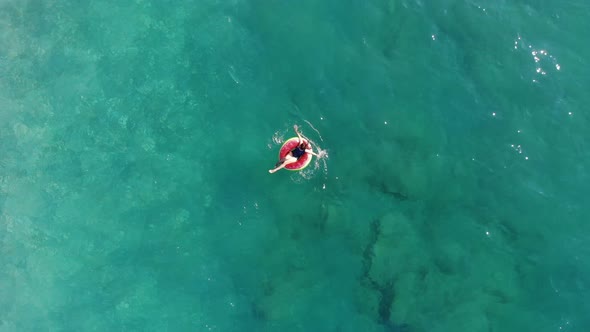 Girl Floating on a Rubber Ring in Sea.